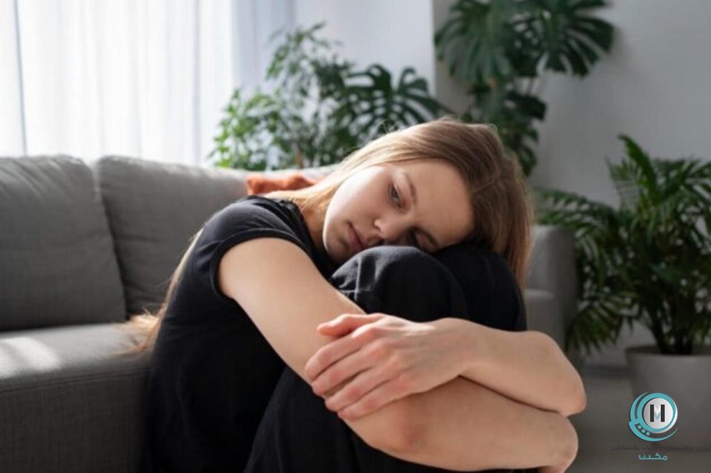 زنی که زانوی خود را بغل گرفته و تاب‌آوری روانی خود را از دست داده است.
